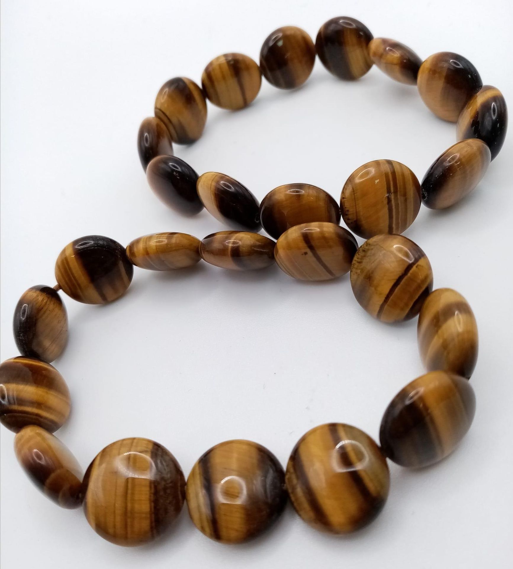 Two Ex Display Tigers Eye Stretch Fit Bracelets. 6cm Inner width at rest. 1.4cm Wide. Each weigh