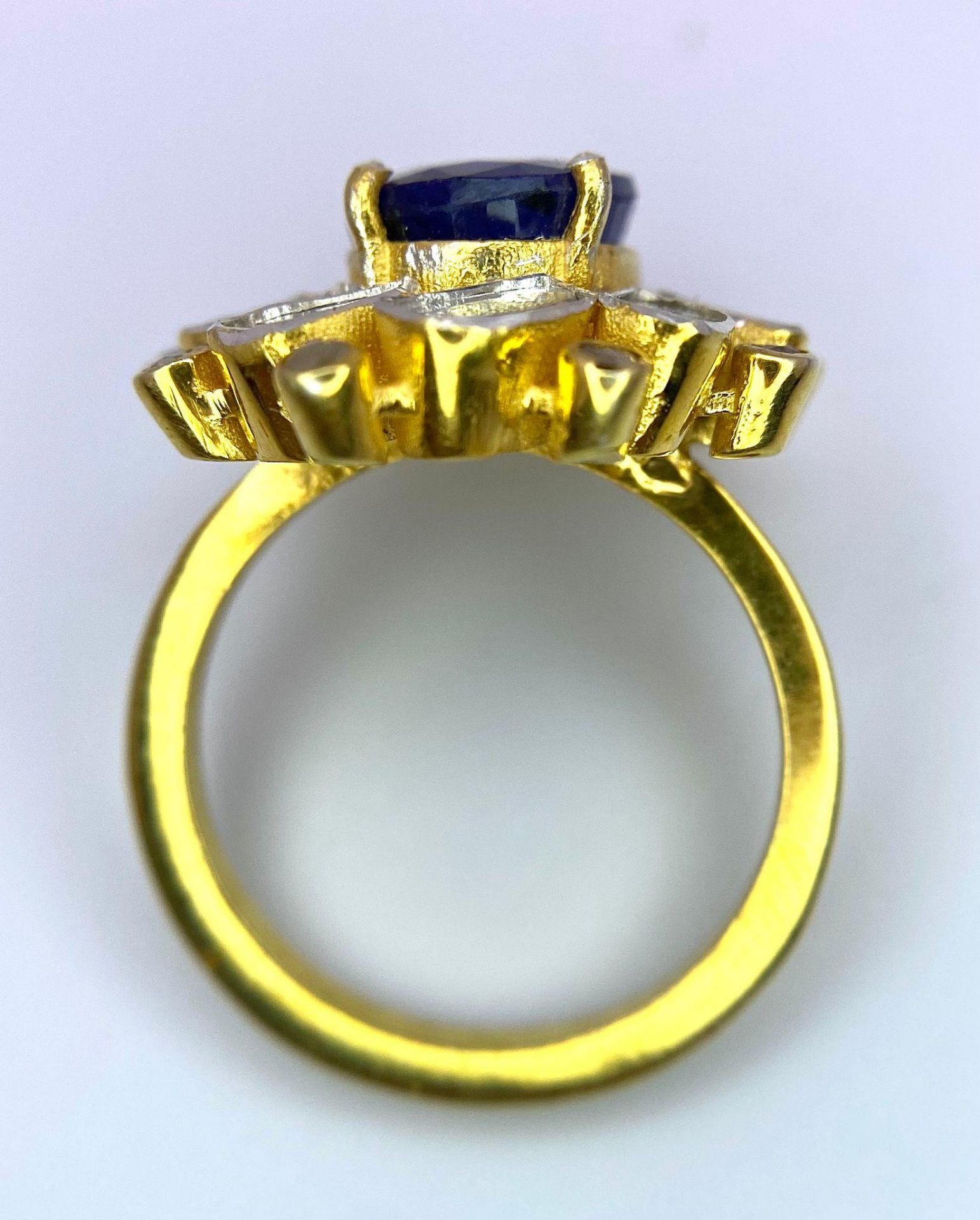 An eye-catching silver and gold ring with an oval cut blue sapphire surrounded by a group of large - Image 3 of 4