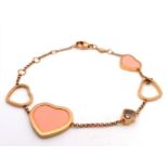 An 18 K yellow gold CHOPARD bracelet with pink stone hearts and a Happy Floating Diamond. Total