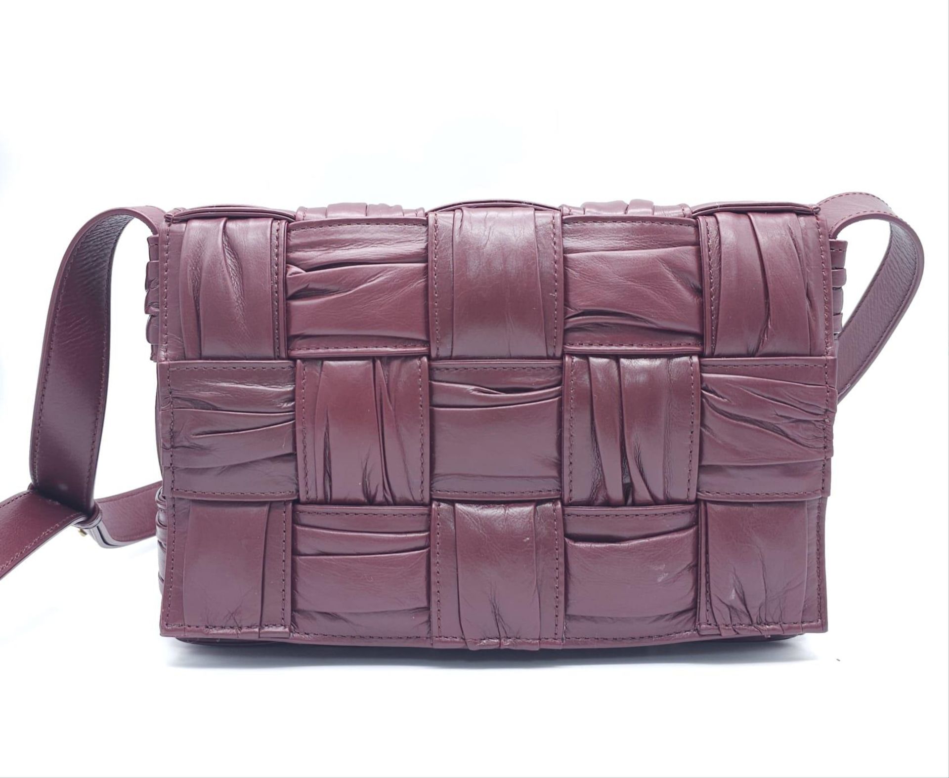 Bottega Veneta Brick Cassette Bag. Smooth burgundy leather, signature orthogonal weaving, adjustable