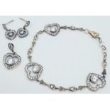 A matching set of fancy 925 silver stone set with heart shape decoration jewellery: A pendant, a