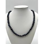 A Black Akoya Cultured Freshwater Pearl Necklace. 5/6mm pearls. 68cm length.