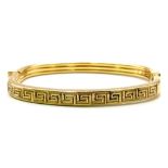 A 9K GOLD ITALIAN DESIGNER HINGED BANGLE WITH GREEK PATTERN ON ONE SIDE . 10.2gms