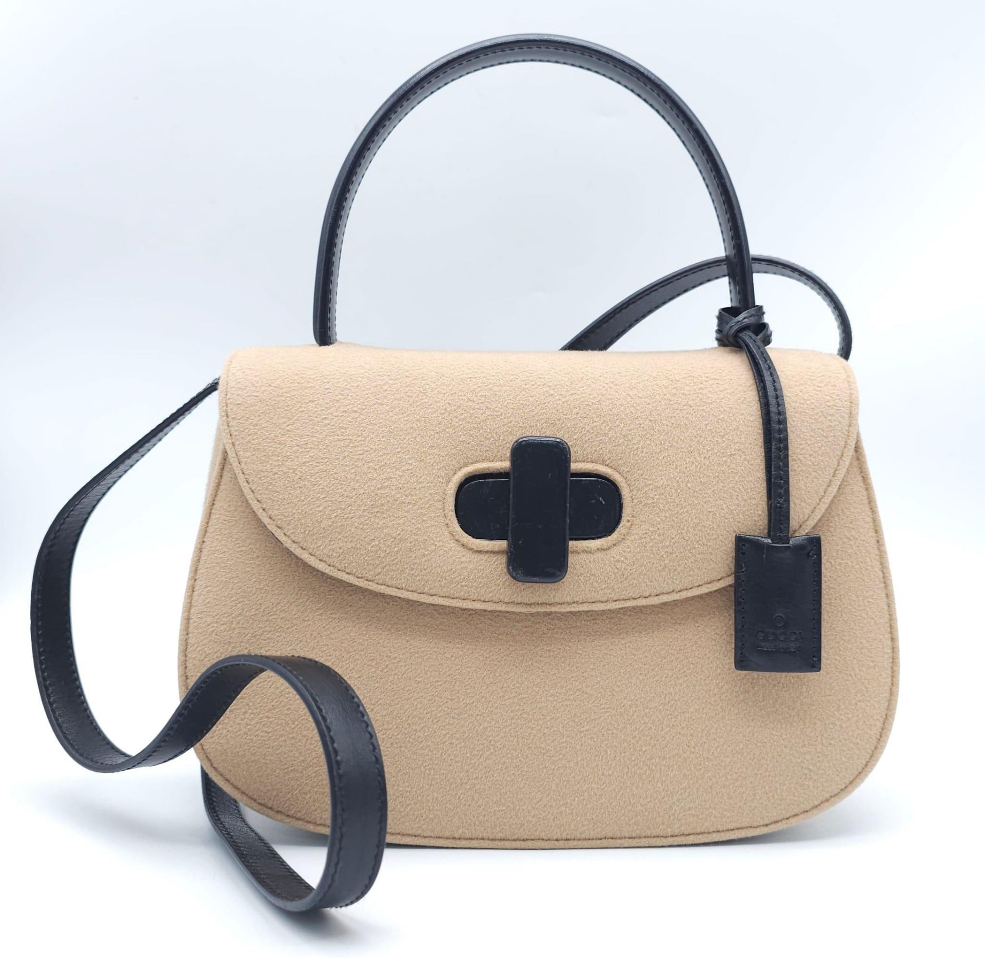 Gucci Tan Wool Purse. This Gucci tan wool purse features a black bar closure, black leather