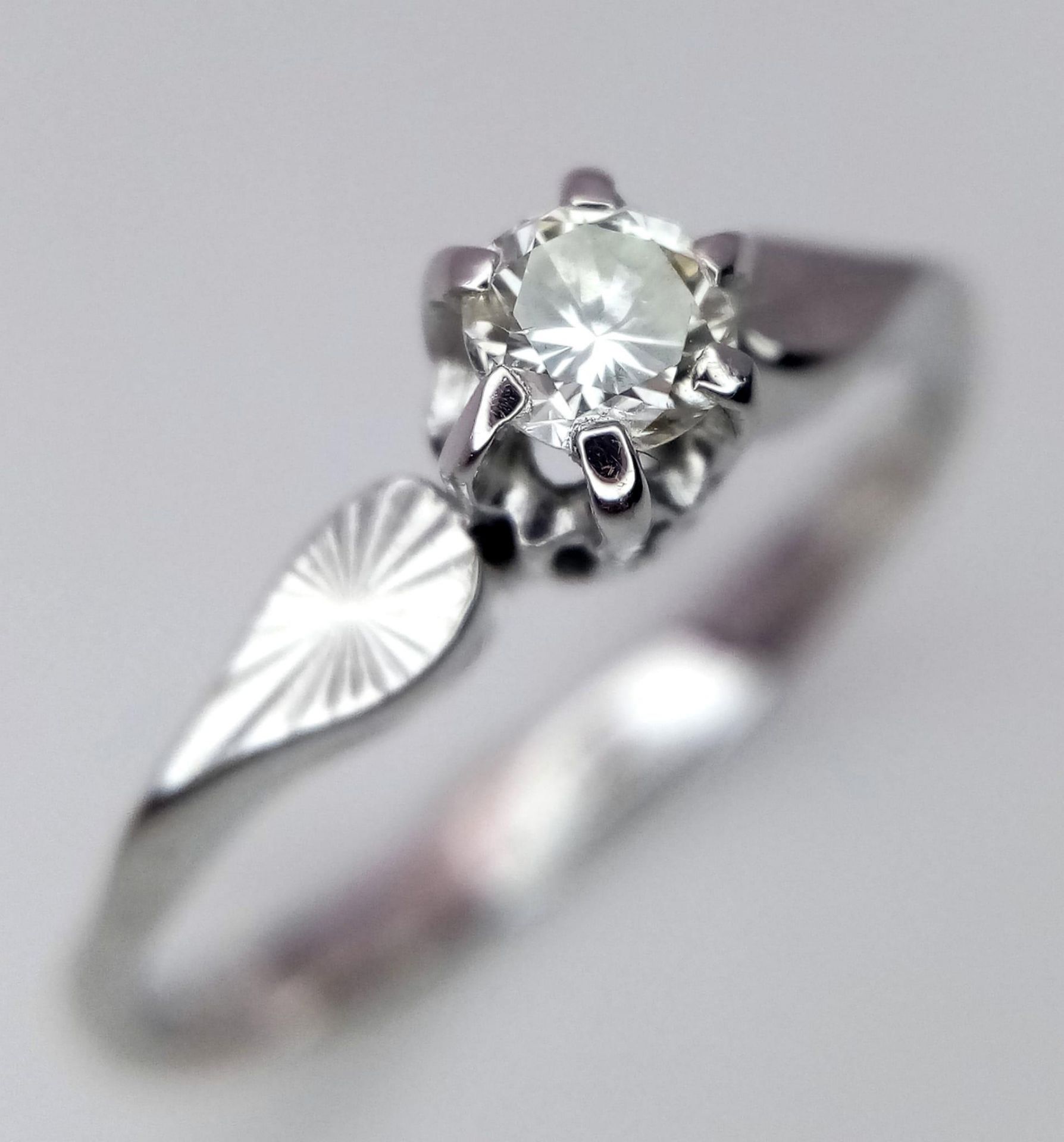 An 18 Carat White Gold Diamond Set Solitaire Ring Size N. Approx .10-.12 Carats. Ring Gross Weight