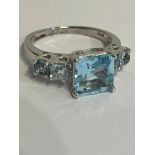 Stunning BLUE TOPAZ and SILVER RING. Having square cut TOPAZ set to top flanked with BLUE TOPAZ