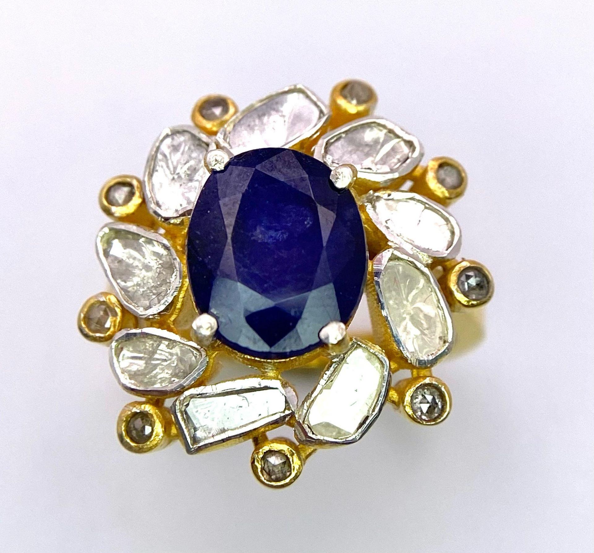 An eye-catching silver and gold ring with an oval cut blue sapphire surrounded by a group of large - Image 2 of 4