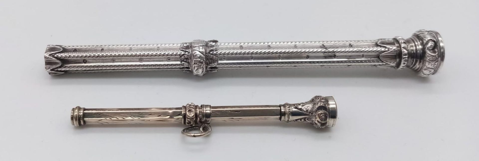 A pair of unmarked, antique jewelled Sliding Pencils. Both ornately patterned, with scrolling