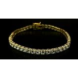 A STUNNING 14K GOLD TENNIS BRACELET WITH BRIGHT SPARKLING ZIRCONIA STONES. 9.8gms