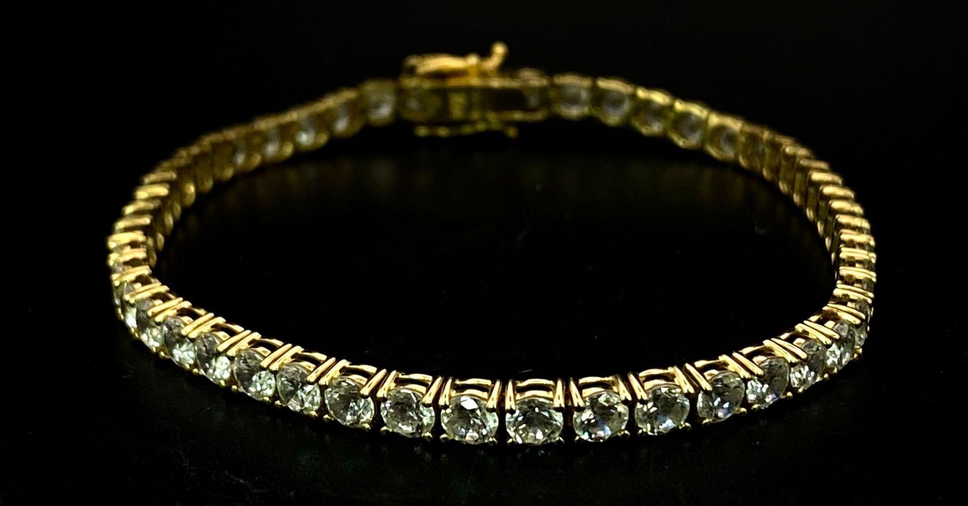 A STUNNING 14K GOLD TENNIS BRACELET WITH BRIGHT SPARKLING ZIRCONIA STONES. 9.8gms