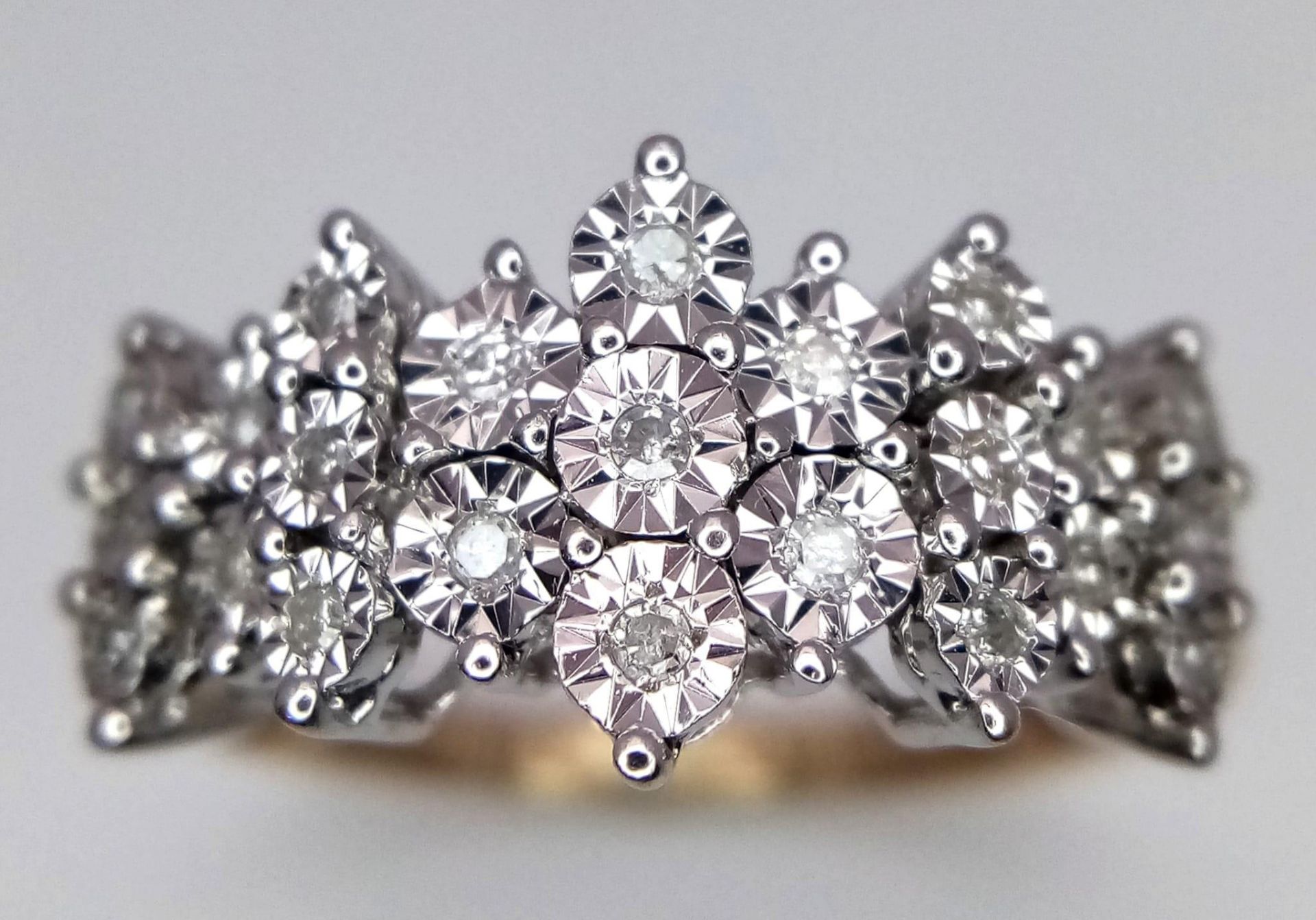 An 18K Yellow Gold Diamond Cluster Ring. 23 round cut diamonds create the perfect crown effect. Size