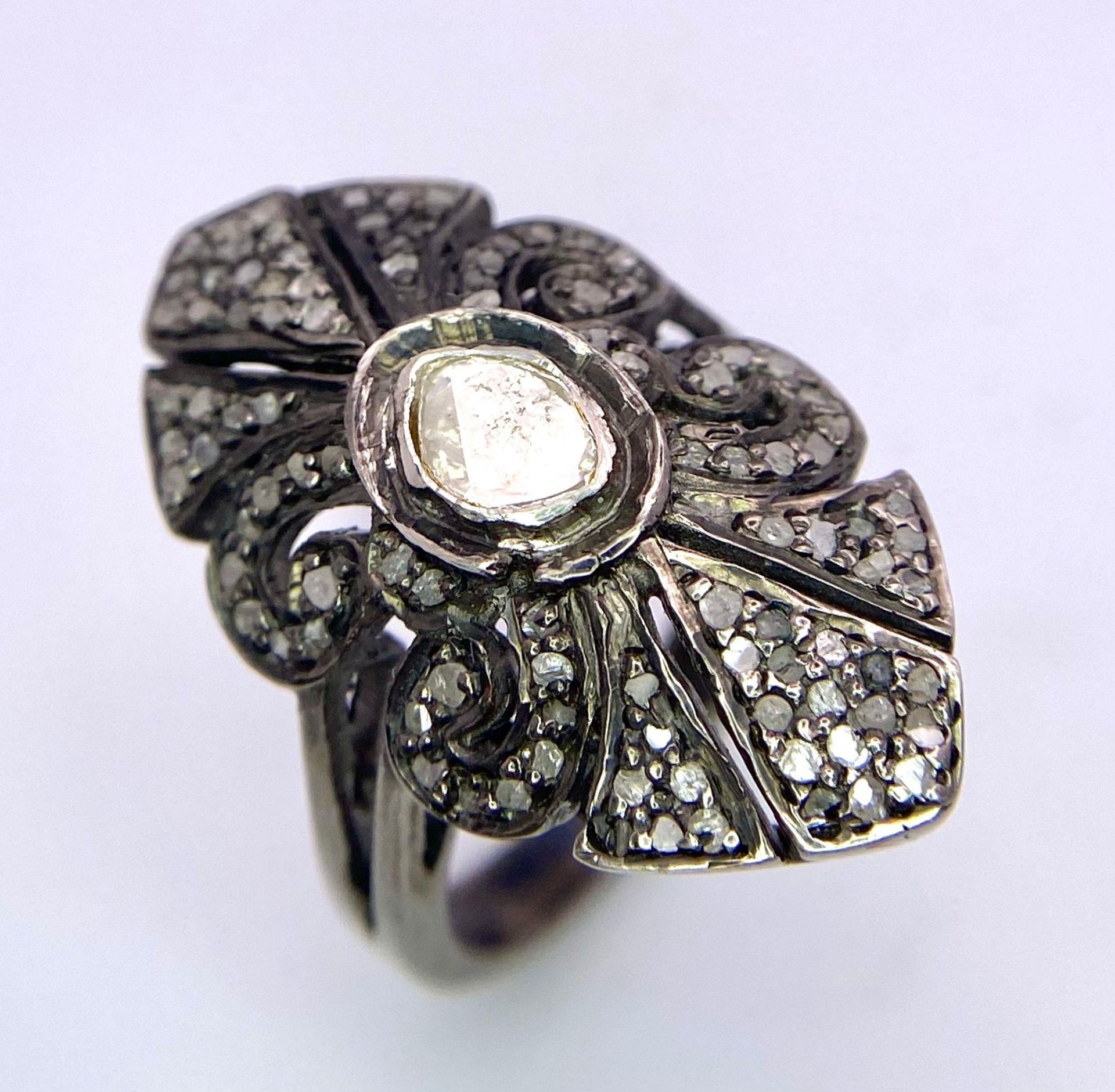 An Edwardian, ART NOUVEAU sterling silver ring with a large natural untreated diamond surrounded