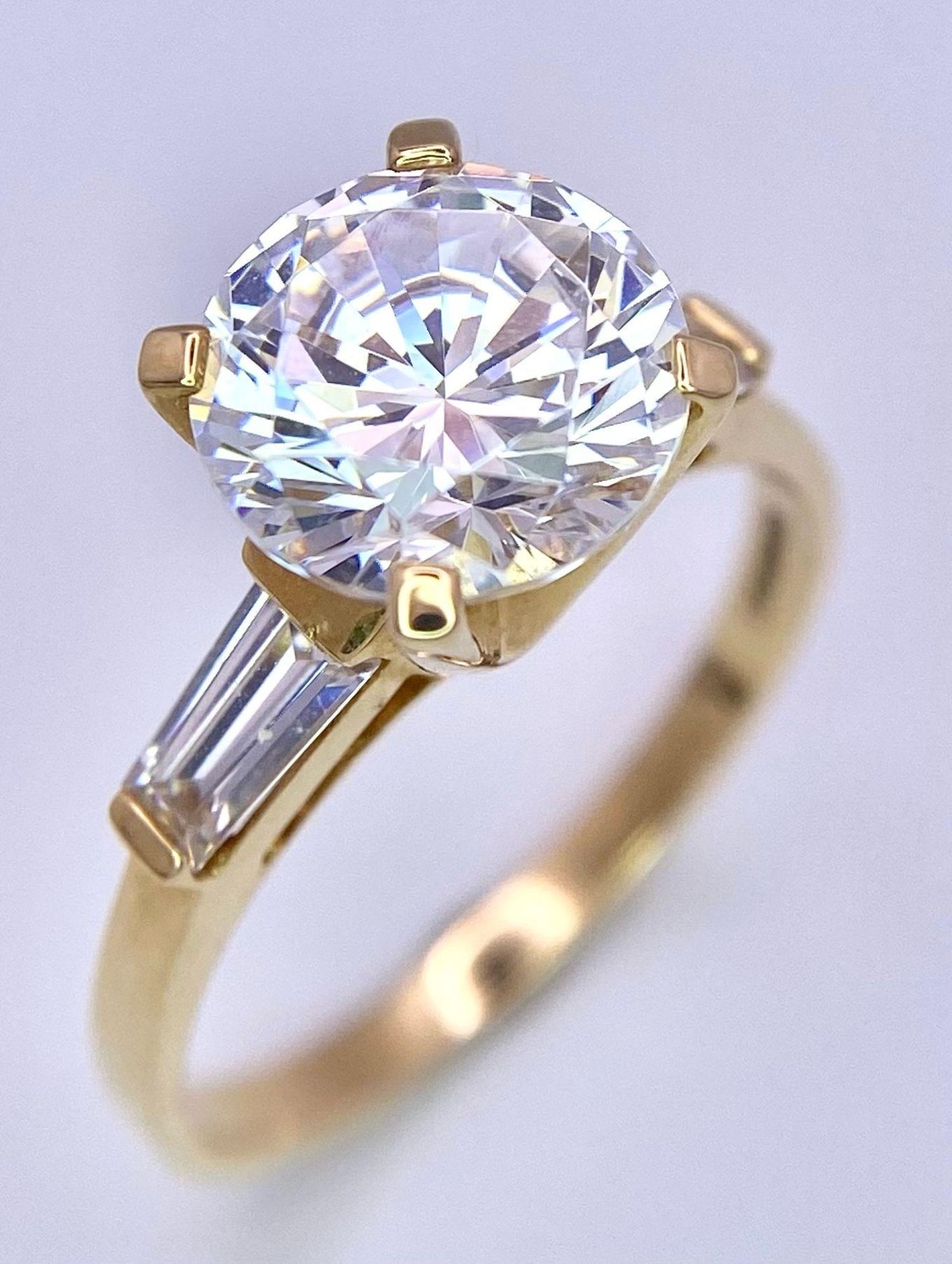 A VERY IMPRESSIVE 14K GOLD RING WITH A 3ct ZIRCONIA STONE AND BAGUETTES SHOULDERS . 4.5gms size S - Image 2 of 7