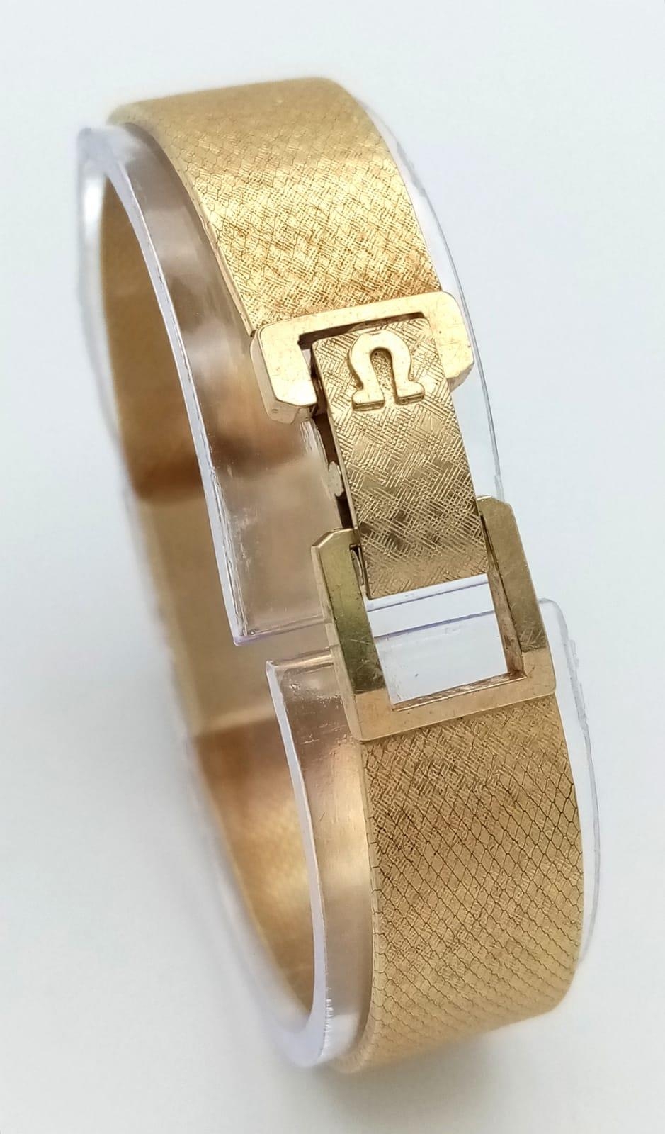 A VINTAGE LADIES 14K GOLD OMEGA CLASSIC 17 JEWELS MANUAL WIND WRIST WATCH WITH PATTERNED GOLD TONE - Image 3 of 6