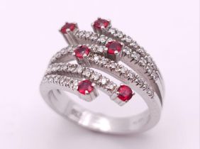 An 18K White Gold, Ruby and Diamond Five-Stem Swirl Ring. Size M. 7.1g total weight.