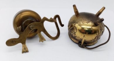 A vintage brass witches cauldron and a pot on a lizards back.