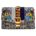 Gucci Snakeskin Leather, Floral Embodied Bag. This versatile bag can be carried as a clutch or a