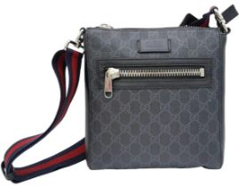 A Black Gucci Cross-Over Satchel. With a quality red & navy adjustable strap, this satchel can be