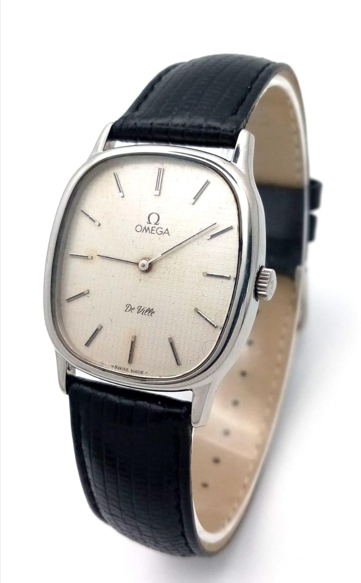 AN OMEGA DE VILLE IN STAINLESS STEEL WITH MANUAL WINDING MOVEMENT AND ON A BLACK LEATHER STRAP .