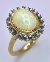 A Vintage 18K Yellow and White Gold, Opal Ring. Central opal cabochon with excellent colour-play.