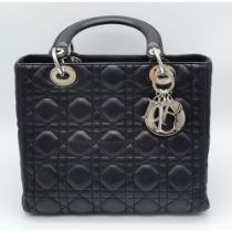 The Season's Lady Dior bag by Christian Dior is crafted from black quilted Lambskin leather. The