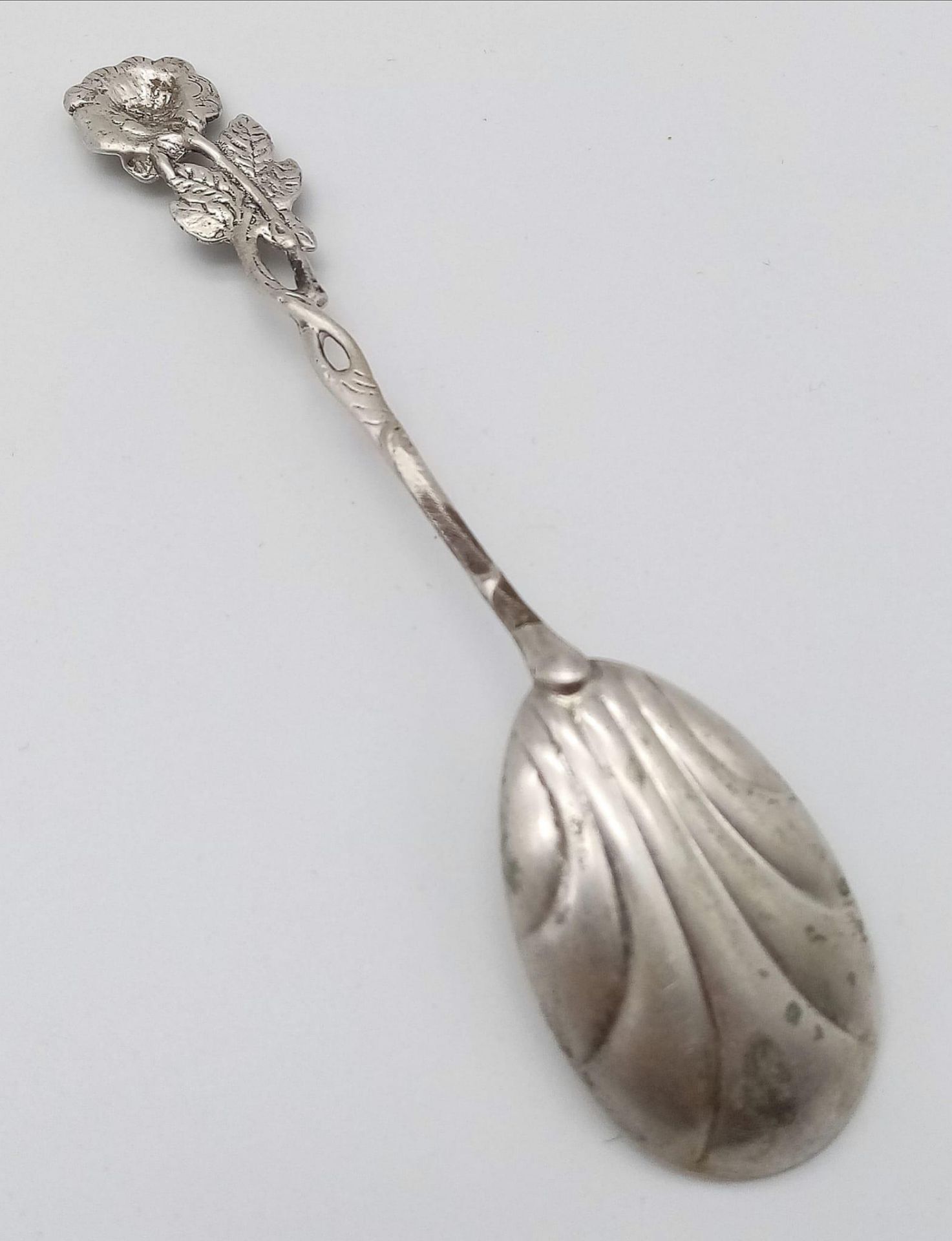 An antique silver spoon. A rose designed handle which flows down to a clam-shell like spoon bowl. - Image 3 of 4