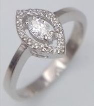 An 18K White Gold and Marquise Cut Diamond Ring. Central bright marquise cut diamond with a round