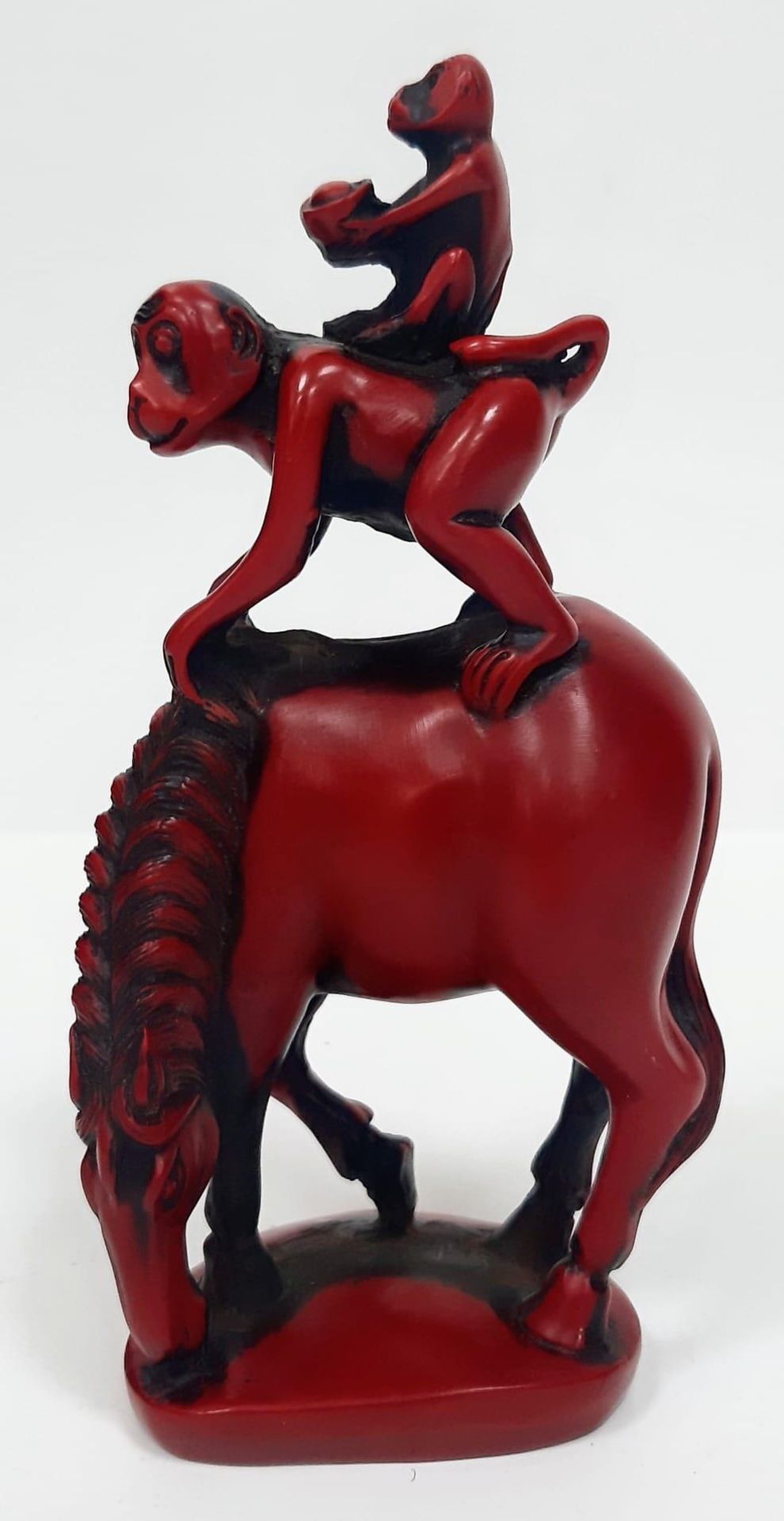 A Coral Red Carved Figurine of two Monkeys on a Horse. Stands 16.5cm tall by 6cm wide.