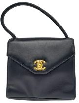 A Vintage Chanel Black Handbag. Leather exterior with a single handle, gold toned hardware, the