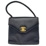 A Vintage Chanel Black Handbag. Leather exterior with a single handle, gold toned hardware, the
