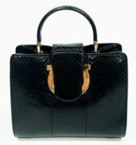 A Salvatore Feregamo Black Snake Skin Handbag. Single top handle with gold tone hardware and a