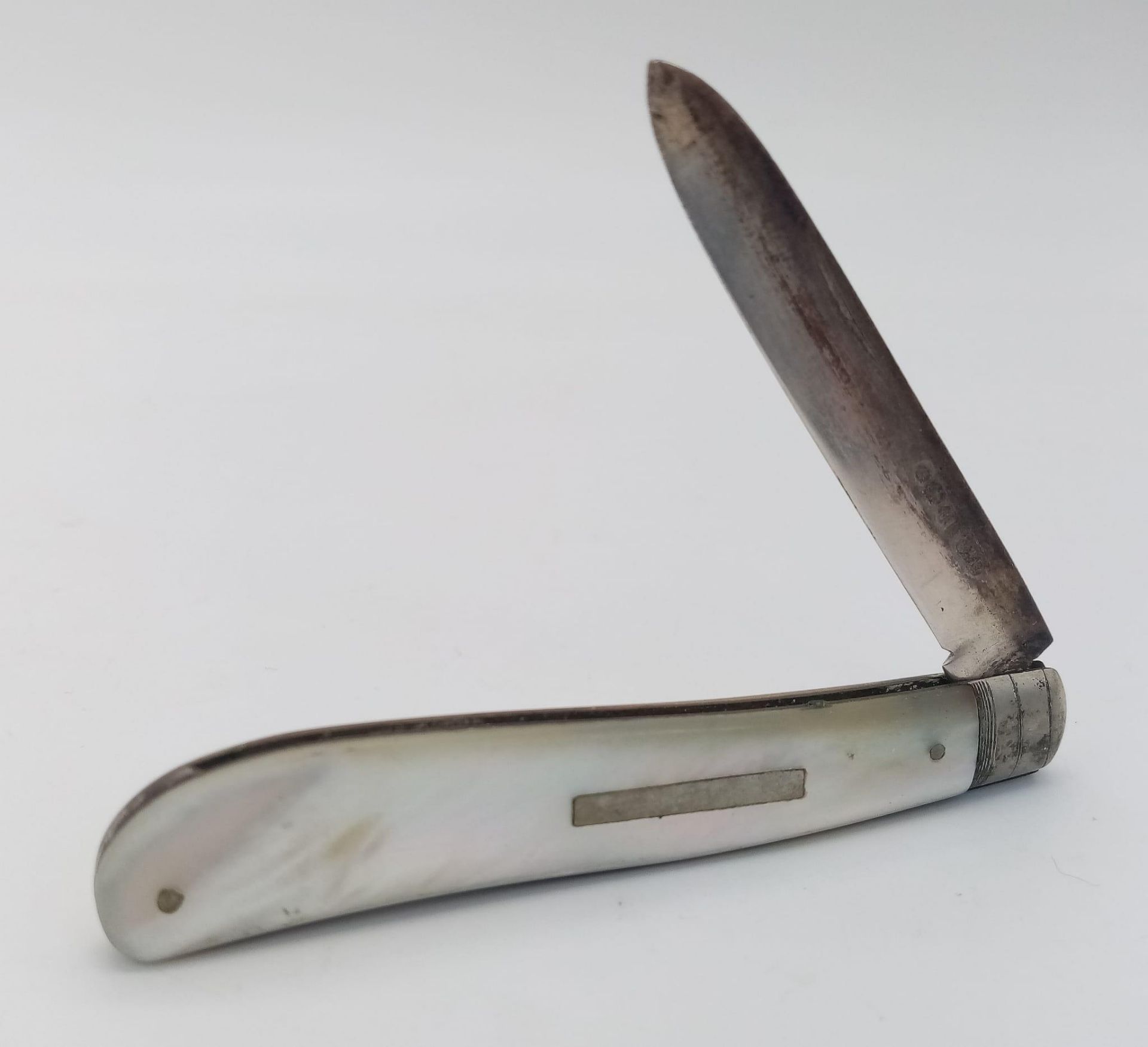 An antique sterling silver Mother of pearl knife. Full hallmarks Sheffield, 1921. Total weight 26.