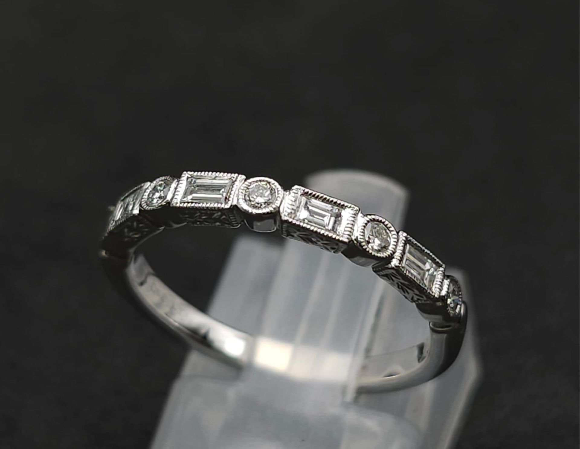 A 9K White Gold and Diamond Half Eternity Ring. Size N. 2g total weight.