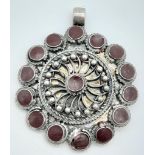 A 925 Silver, Circular Pendant. Nicely designed with incorporated red stones. Length: 4cm Weight: