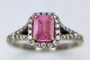 A Beaverbrooks Pink Sapphire and Diamond Ring. Central gemstone with a diamond halo and accents.
