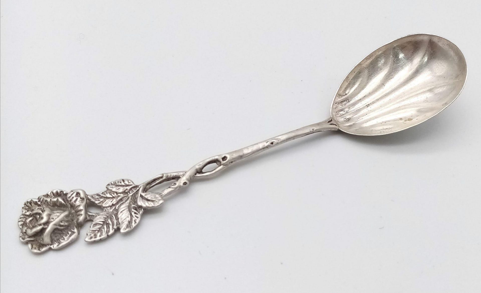 An antique silver spoon. A rose designed handle which flows down to a clam-shell like spoon bowl. - Image 2 of 4