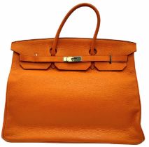 A Hermes Togo Birkin Bag. Highly in demand, this famed Orange Birkin is constructed with a