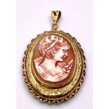 A Vintage 9K Yellow Gold Cameo Pendant. Oval cameo amidst ornate and engraved gold. 5.5cm. 16.55g