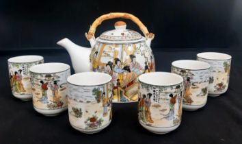 A Chinese Tea Set with 6 cups. Comprising of a Teapot with bamboo handle and six Chinese Tea Cups.