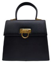 A Salvatore Ferragamo Black Iconic Top Handle Bag. Leather exterior with gold toned hardware, 4
