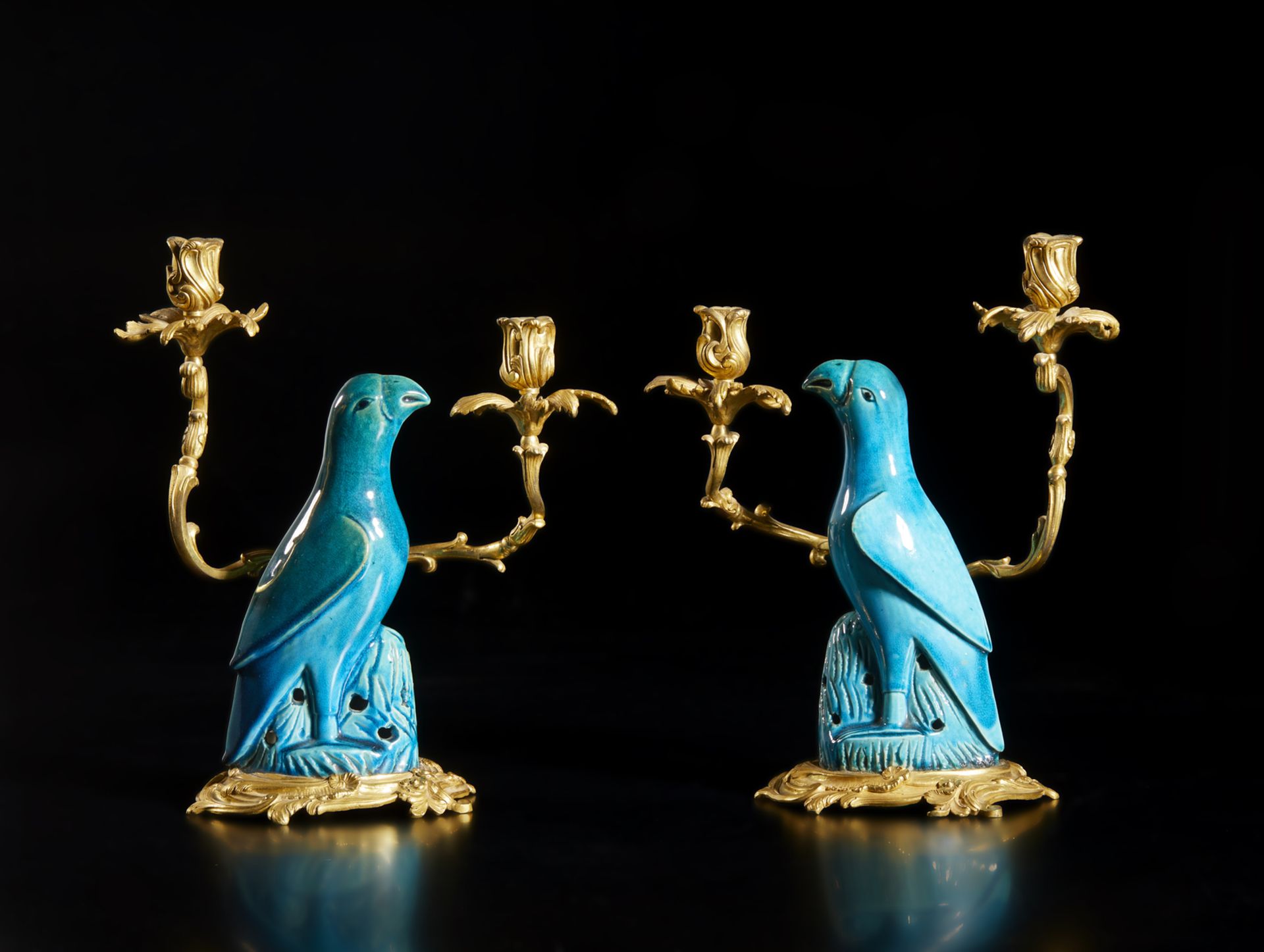 Arte Cinese  A pair of gilded bronze chandlesticks with blue glazed porcelain parrotsChina, Qing, 19