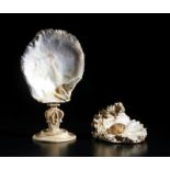 . A oyster shell mounted on base and another with a glass pearl within.