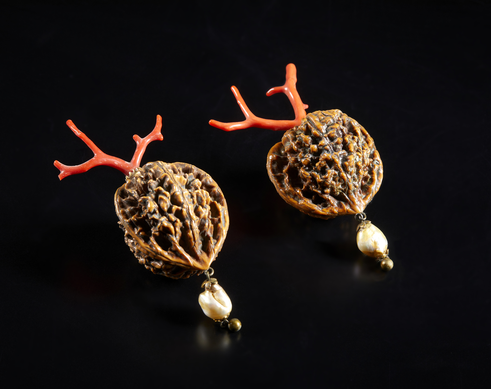 . Two walnuts mounted with small red coral branchItaly, 20th century.