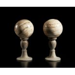 . A pair of onix spheres mounted on wooden base.