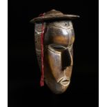 Arte africana Nigeria, Urhobo Wooden Urhobo mask with hat,Wood, hair.Signs and patina of use. .