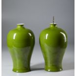 A pair of green glazed porcelain meiping vases bearing a Kangxi six charcater mark at the base