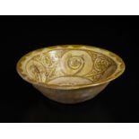 A terracotta bowl with olive green floral decoration Iran, 10th century or later Decorated imitating
