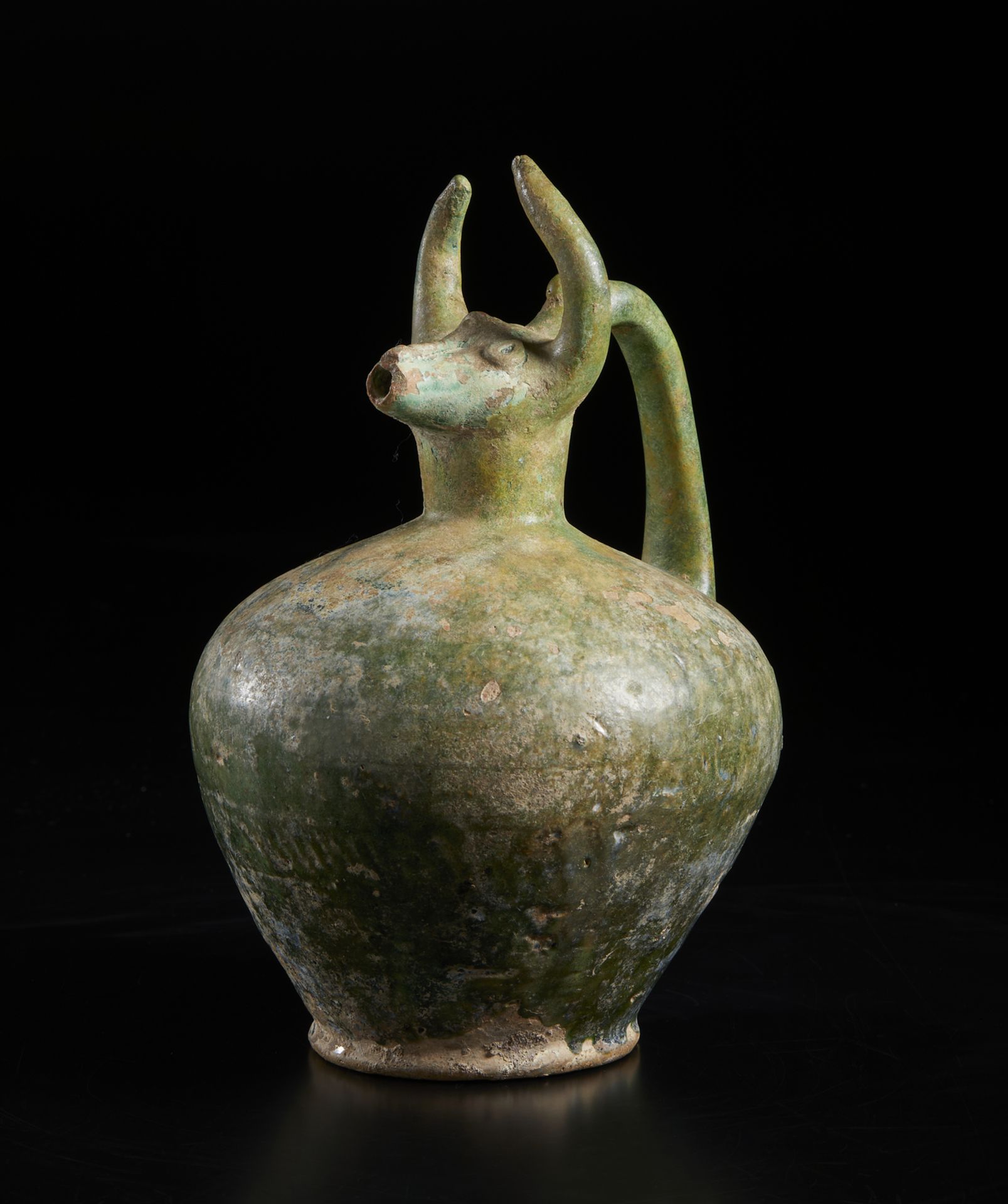 A bull (gav) headed green glazed pottery jug Iran, 12th century Of moulded fritware with a