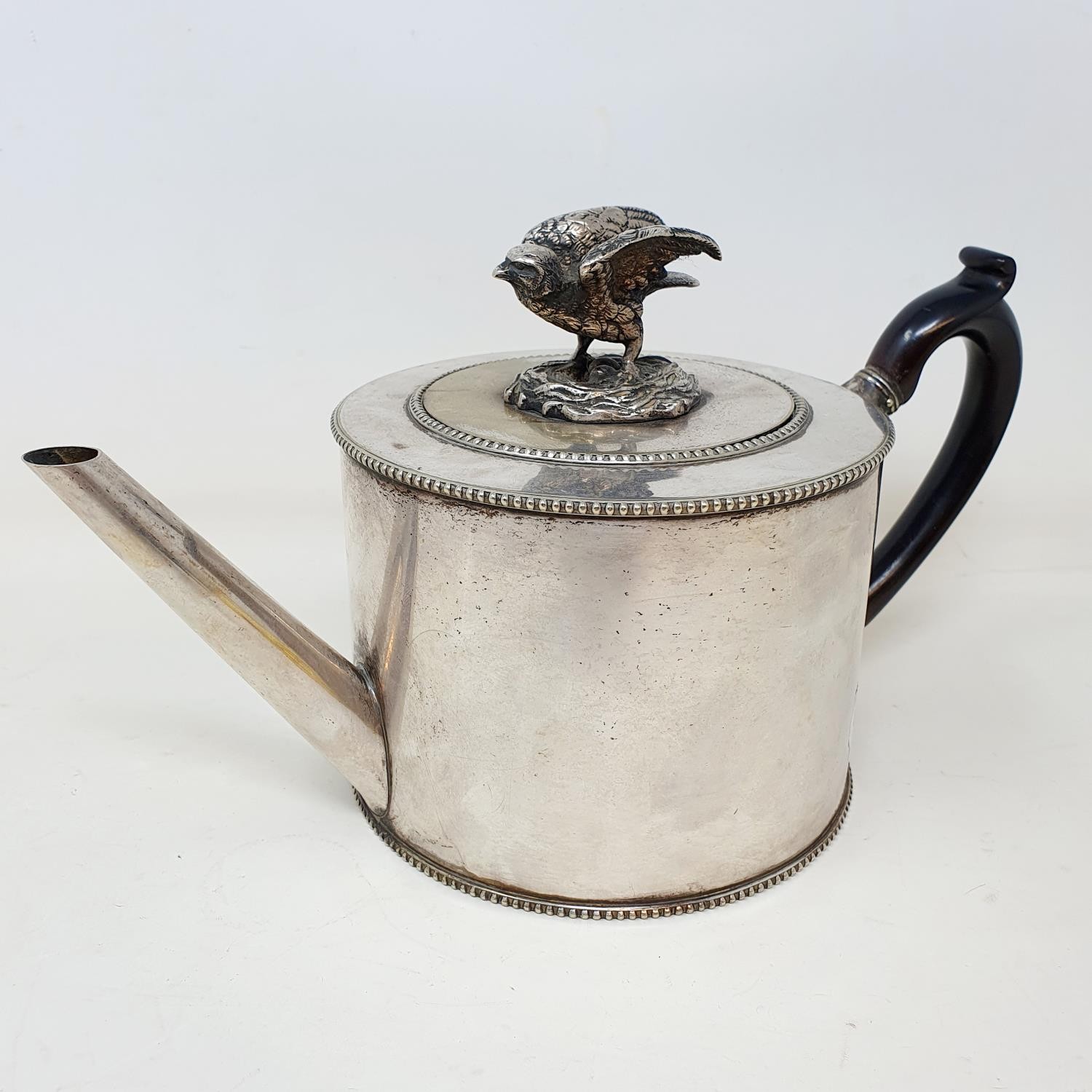 A 19th century silver plated teapot, with a bird finial and an unusual set of dummy hallmarks