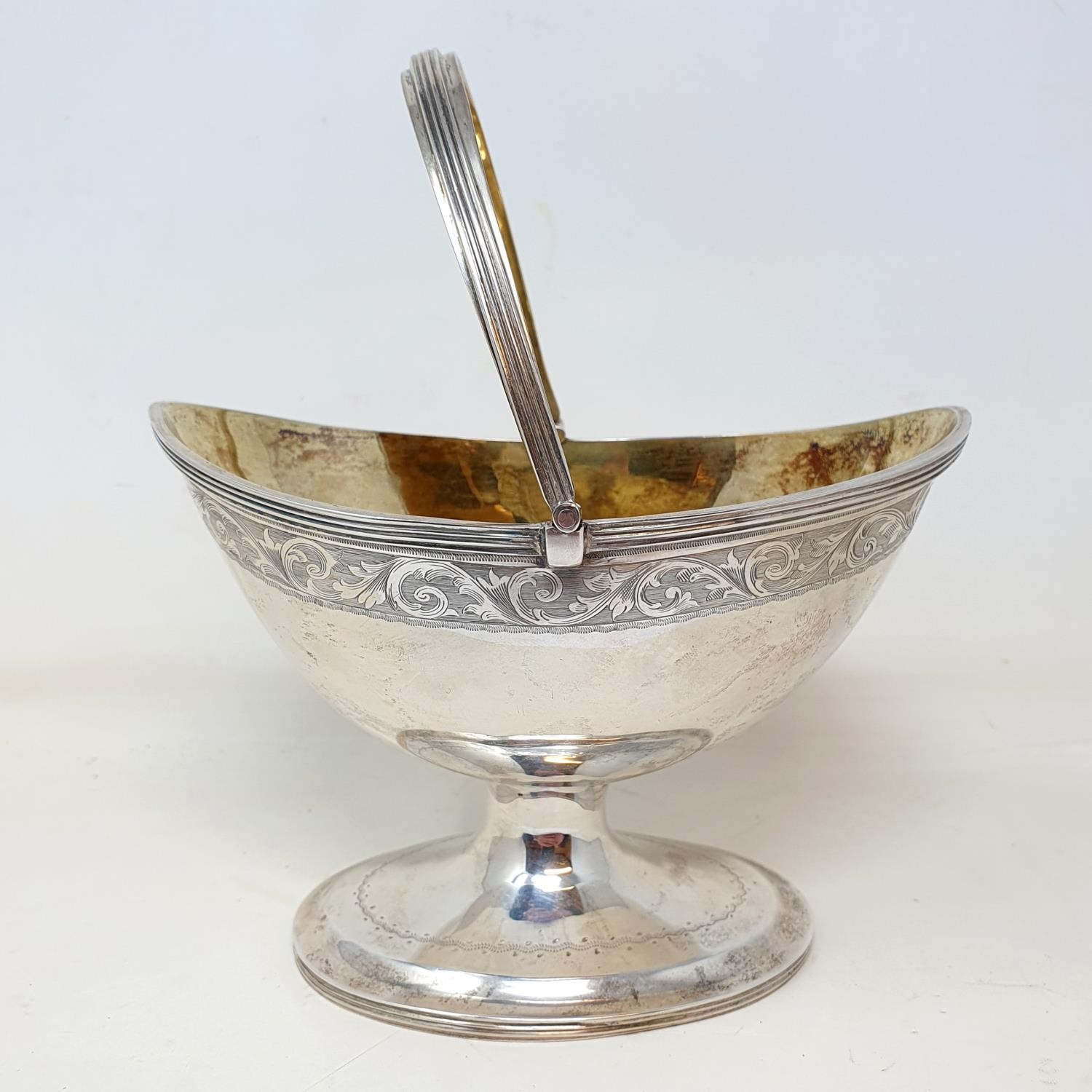 A Victorian silver sugar basket, with a swing handle and engraved decoration, on an oval pedestal - Image 2 of 4